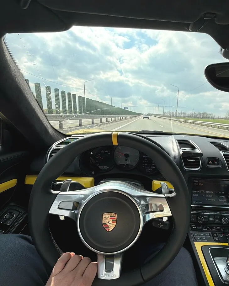 Водитель за рулём Porsche на трассе
